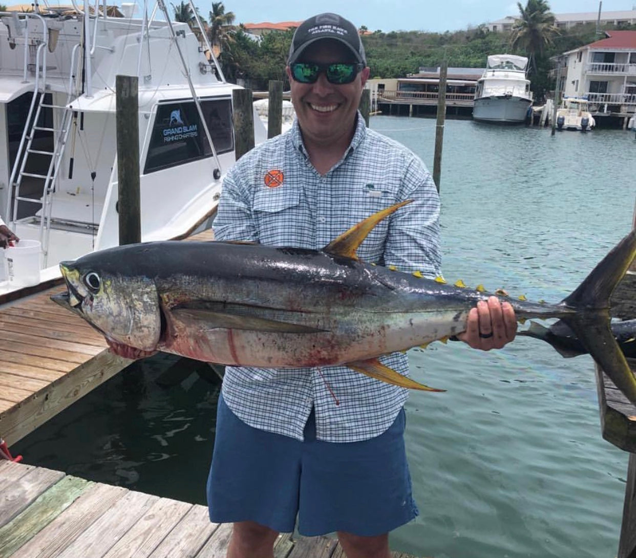 Man holding a large fish wearing a custom Onward Reserve fishing shirt