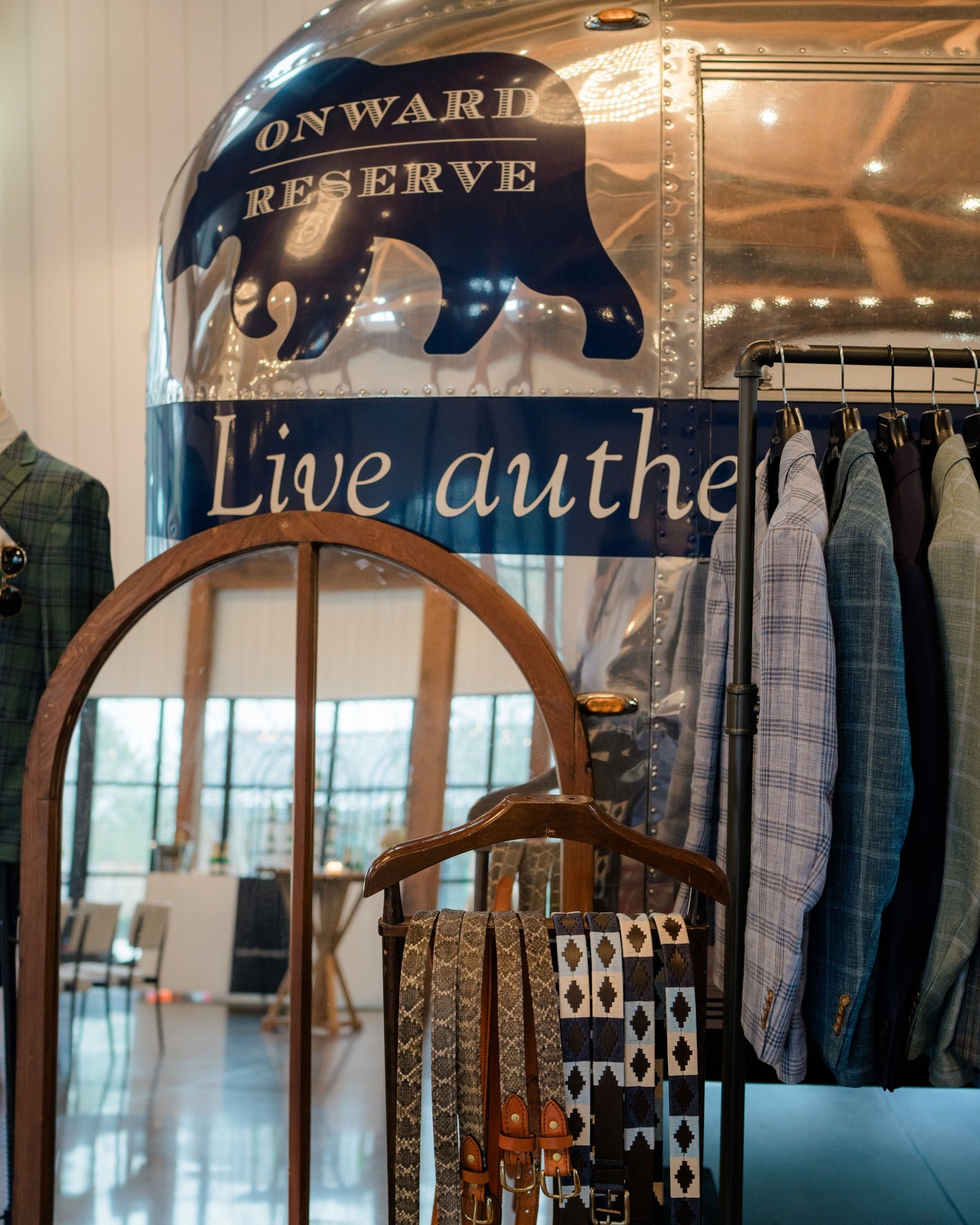 Clothing rack with shirts and a decorative arch in front of an 'Onward Reserve' sign.